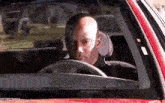 a_bald_man_is_sitting_in_a_red_car_looking_out_the_window.gif.119a581ee7b24e34db62f15d35dc4bfa.gif